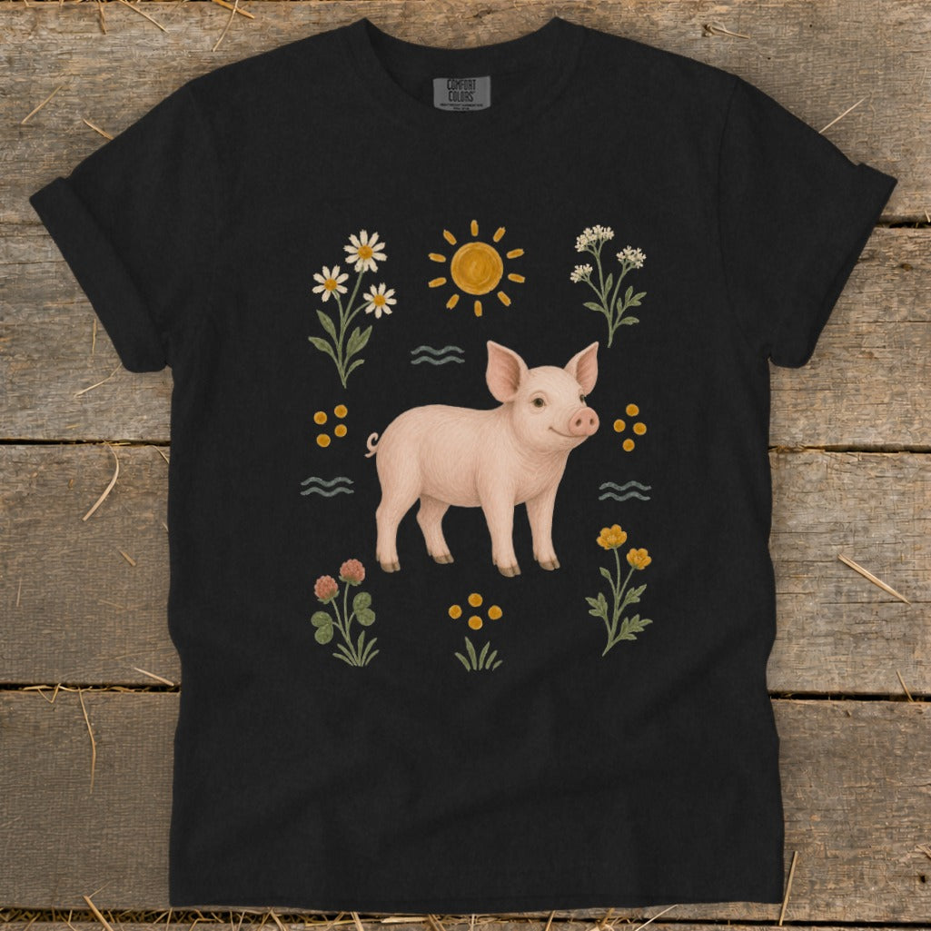 Black t-shirt with a smiling pig surrounded by flowers, sun, and wavy lines.