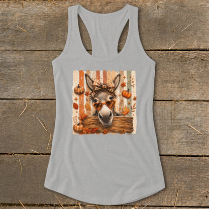 Donkey with heart sunglasses, bow, and pumpkins on a striped background.