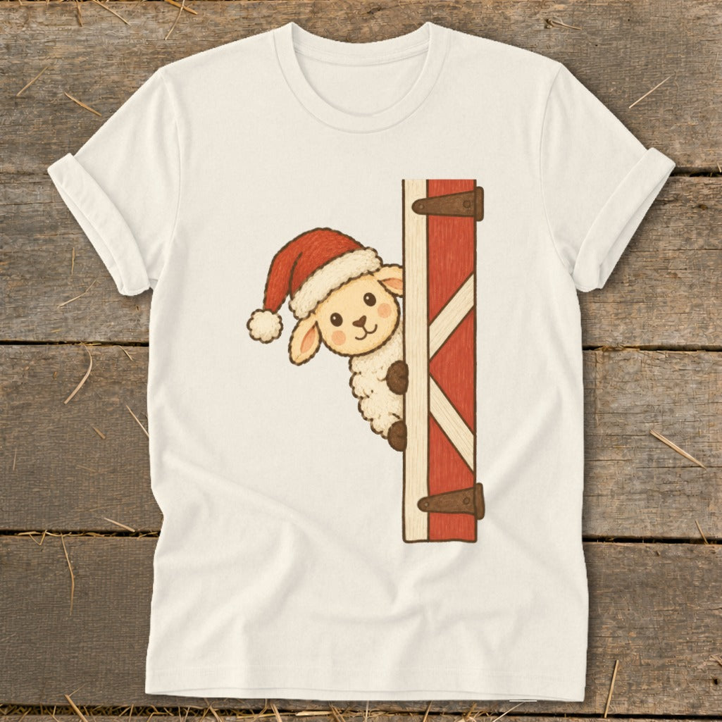 Cream t-shirt with a cartoon sheep in a Santa hat peeking from behind a red barn door.