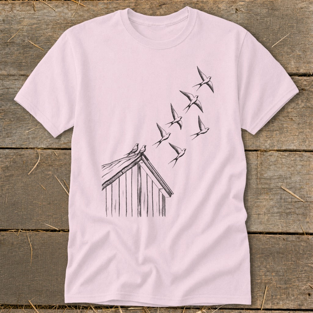 A light pink t-shirt featuring a black line drawing of birds flying from a roof.