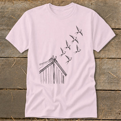 A light pink t-shirt featuring a black line drawing of birds flying from a roof.