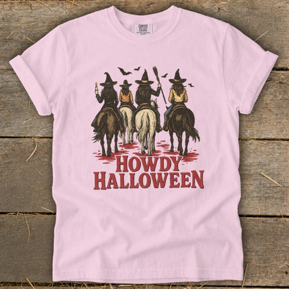 Pink t-shirt with graphic of four witches on horseback and "Howdy Halloween" text.