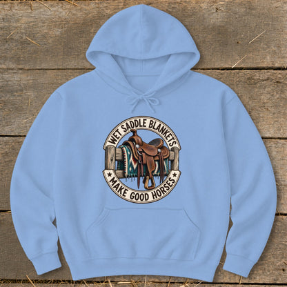 Light blue hoodie with a circular graphic of a saddle and blanket, saying "Wet Saddle Blankets Make Good Horses".