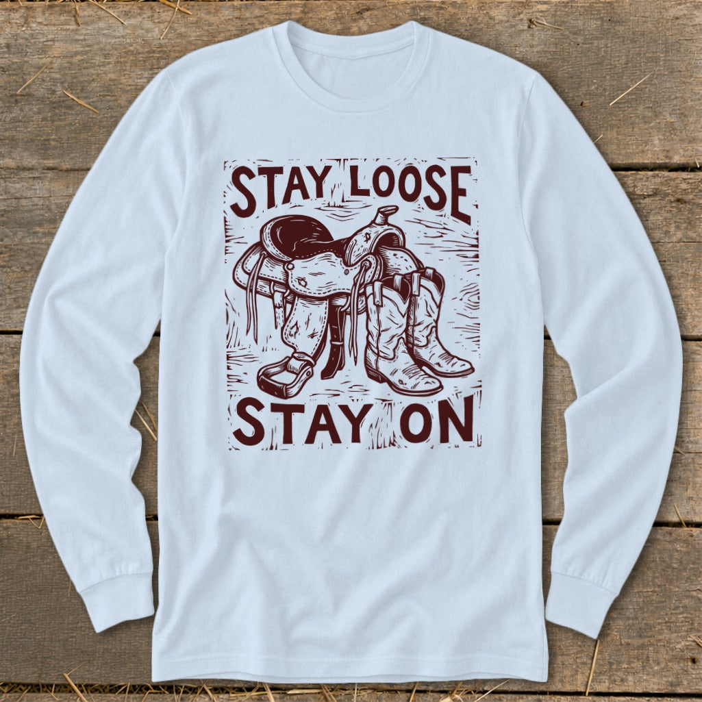 Long sleeve shirt with cowboy saddle, boots, and text "STAY LOOSE STAY ON".