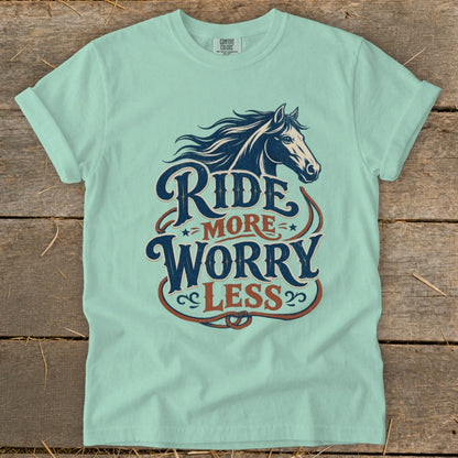 Pale teal t-shirt with a dark blue horse head and "Ride More Worry Less" text.