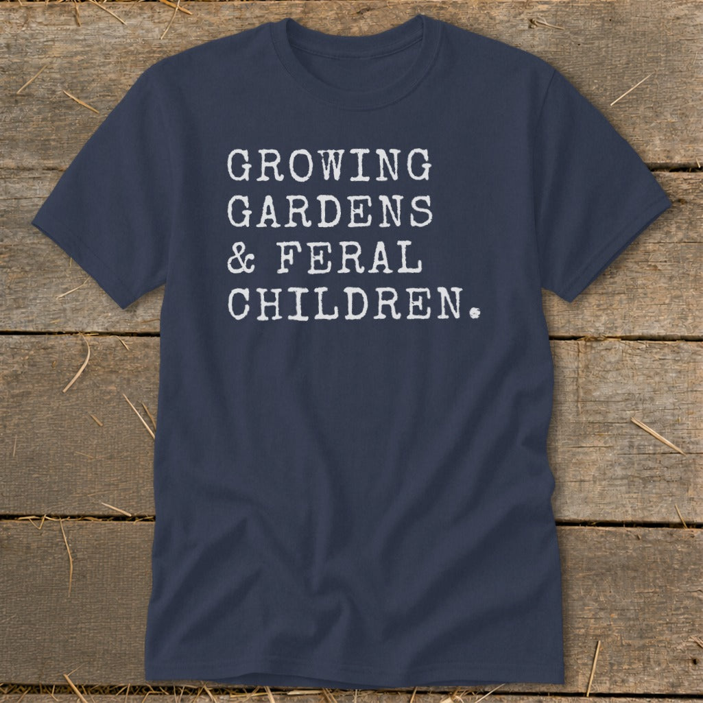 Navy t-shirt with white text: "GROWING GARDENS & FERAL CHILDREN."