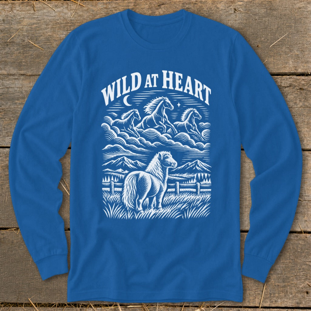 A royal blue long-sleeve t-shirt features a white graphic of horses, mountains, and the text WILD AT HEART.