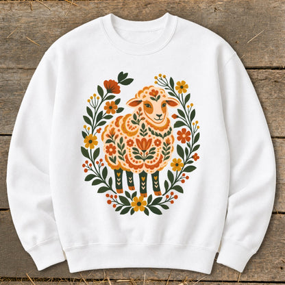 White sweatshirt with a sheep design surrounded by a floral wreath.