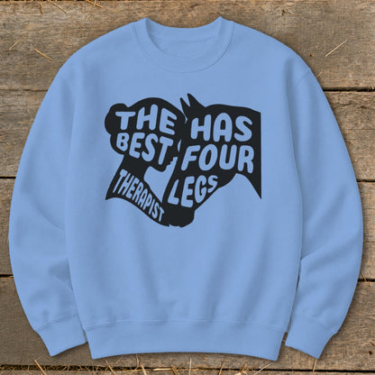 Light blue crewneck sweatshirt with black graphic text: "The best therapist has four legs."