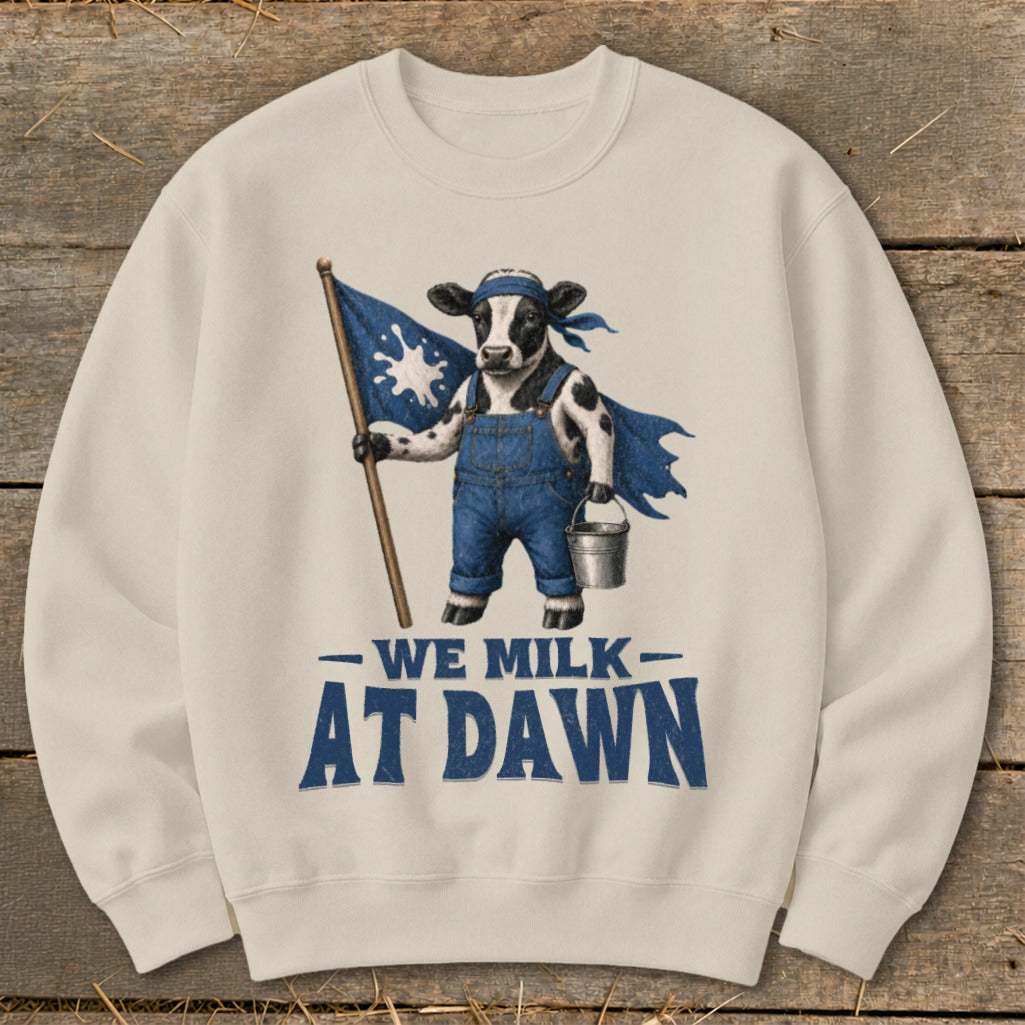 Cow in overalls holding a milk splash flag and pail, "We Milk At Dawn" text.