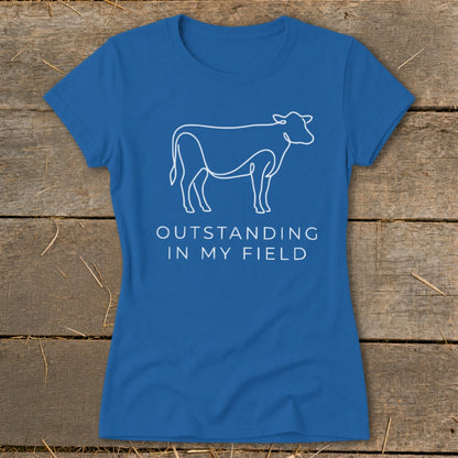 Blue t-shirt with white line drawing of a cow and text "OUTSTANDING IN MY FIELD".
