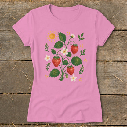 Pink t-shirt with strawberry plant illustration, white flowers, and sun.