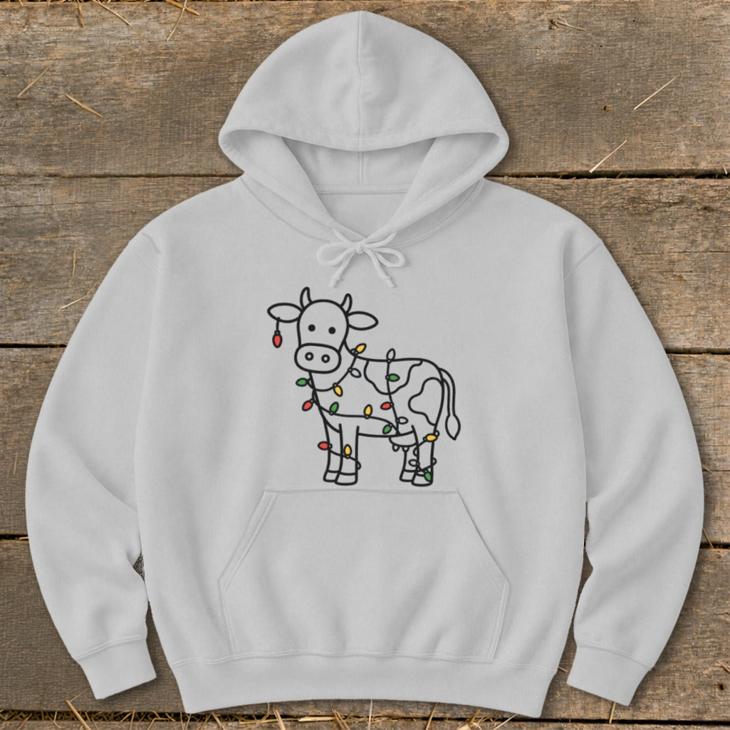 White hoodie with a line drawing of a cow wrapped in colorful Christmas lights.