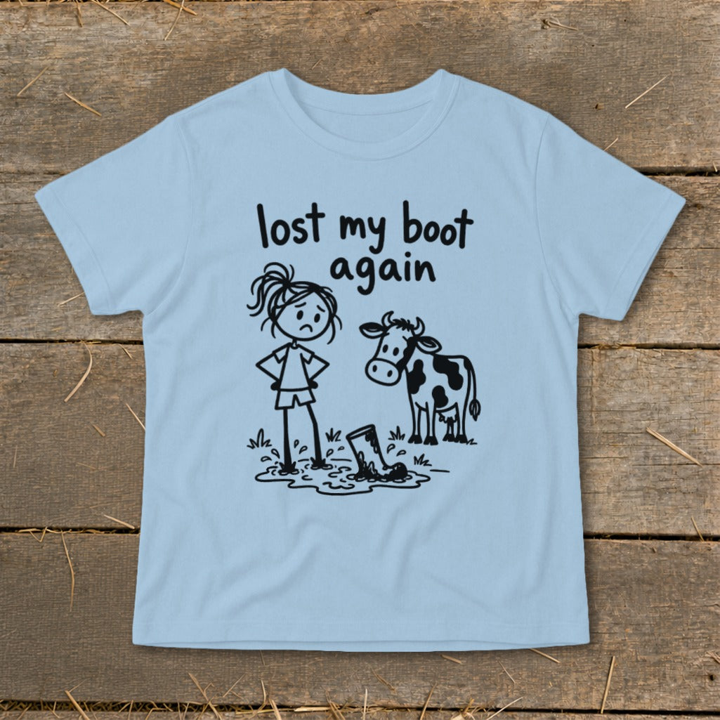 Light blue t-shirt featuring a stick figure graphic of a girl, cow, and muddy boot with the text "lost my boot again."
