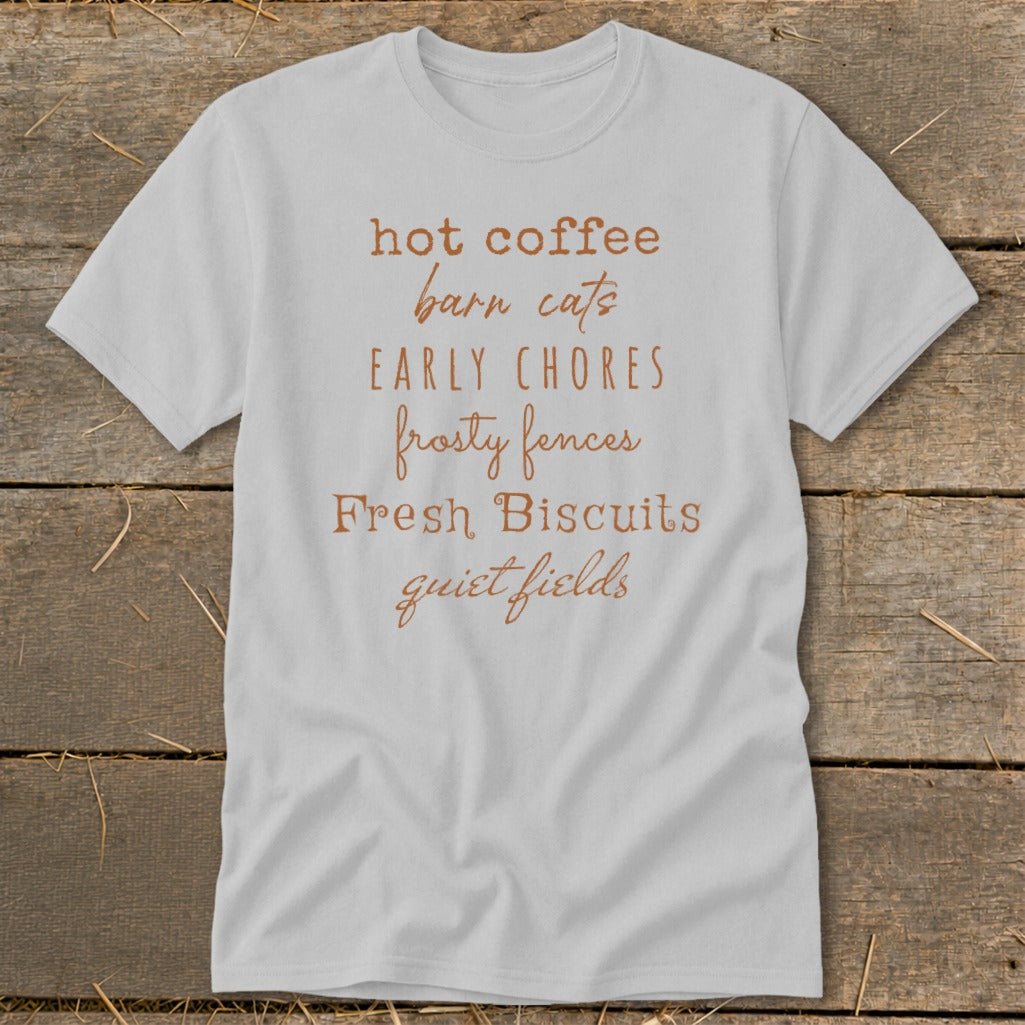 Light gray t-shirt with brown text listing "hot coffee, barn cats, EARLY CHORES, frosty fences, Fresh Biscuits, quiet fields".
