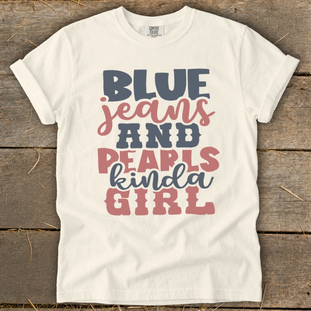 Cream t-shirt with "BLUE JEANS AND PEARLS kinda GIRL" text graphic.