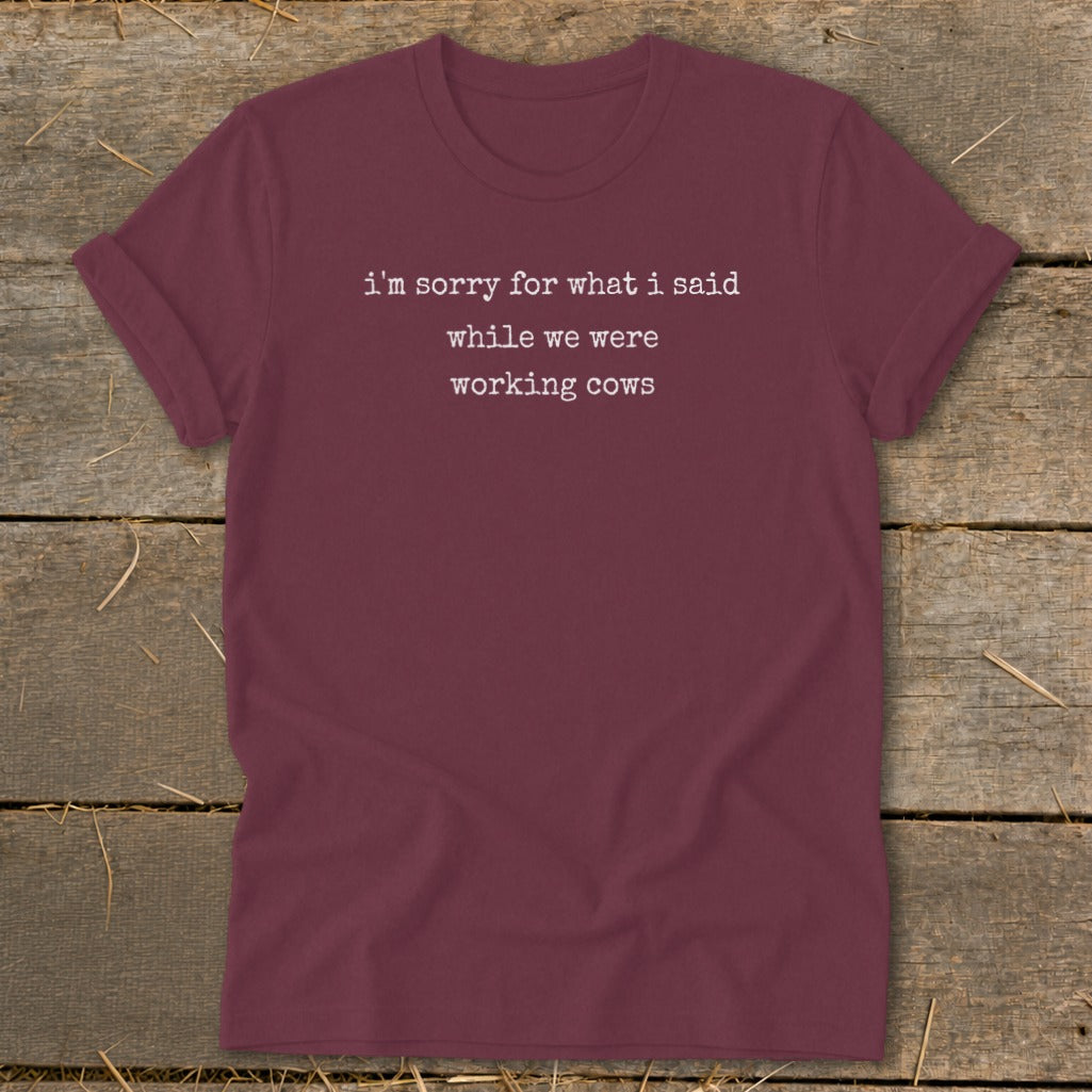 Maroon t-shirt with white text: "i'm sorry for what i said while we were working cows".