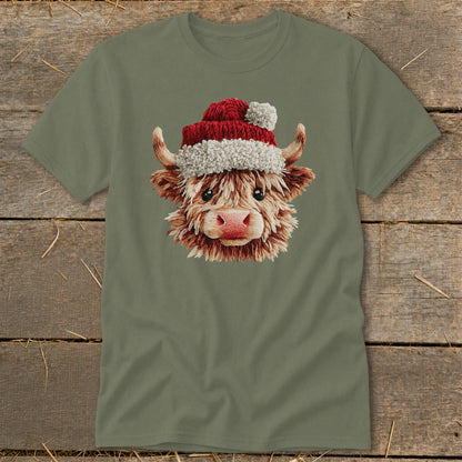 Highland cow wearing a Santa hat on a khaki t-shirt.