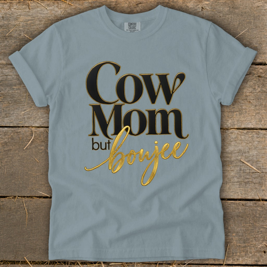 Light blue t-shirt with "Cow Mom but boujee" text in black and gold lettering.