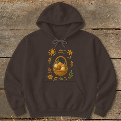 Brown hoodie with a graphic of a basket of eggs, sun, flowers, and leaves.