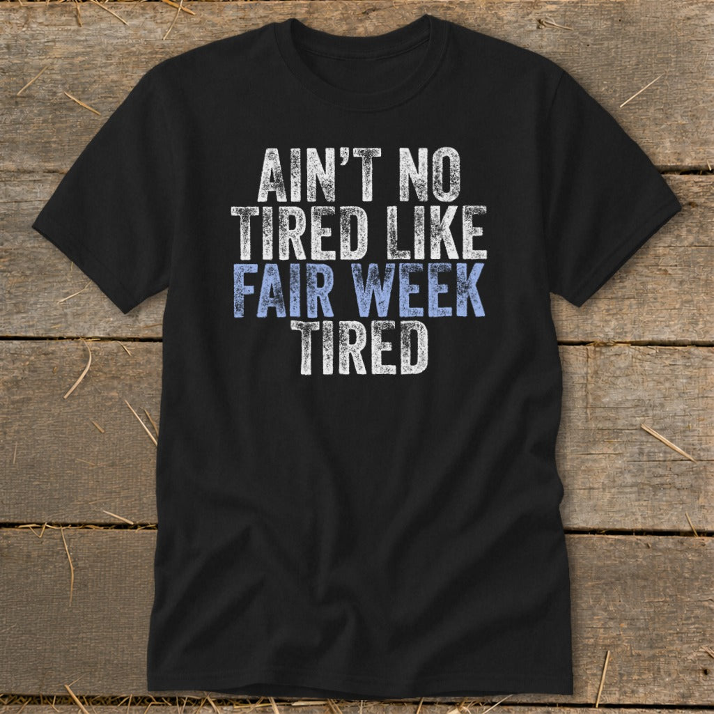 Black t-shirt with "AIN'T NO TIRED LIKE FAIR WEEK TIRED" text.