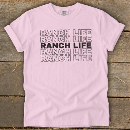 Light pink t-shirt featuring the text Ranch Life printed in bold, repeating black block letters across the chest.