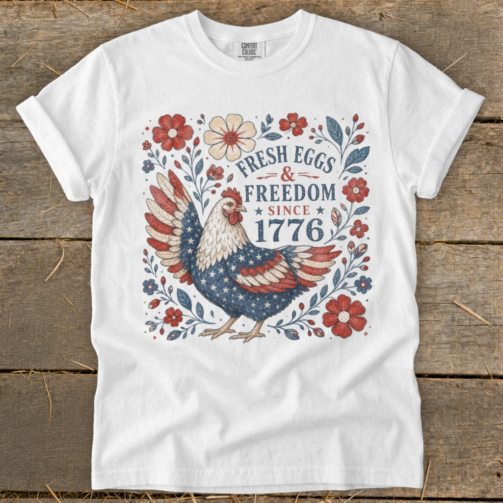 White t-shirt with chicken design and text "Fresh Eggs & Freedom Since 1776".