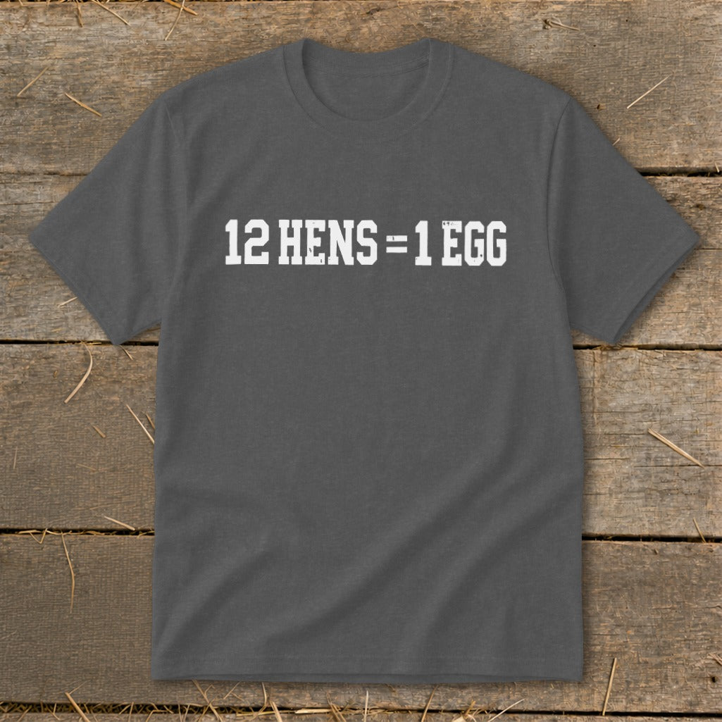 Dark grey t-shirt featuring the white text 12 HENS = 1 EGG displayed on a rustic wooden background.