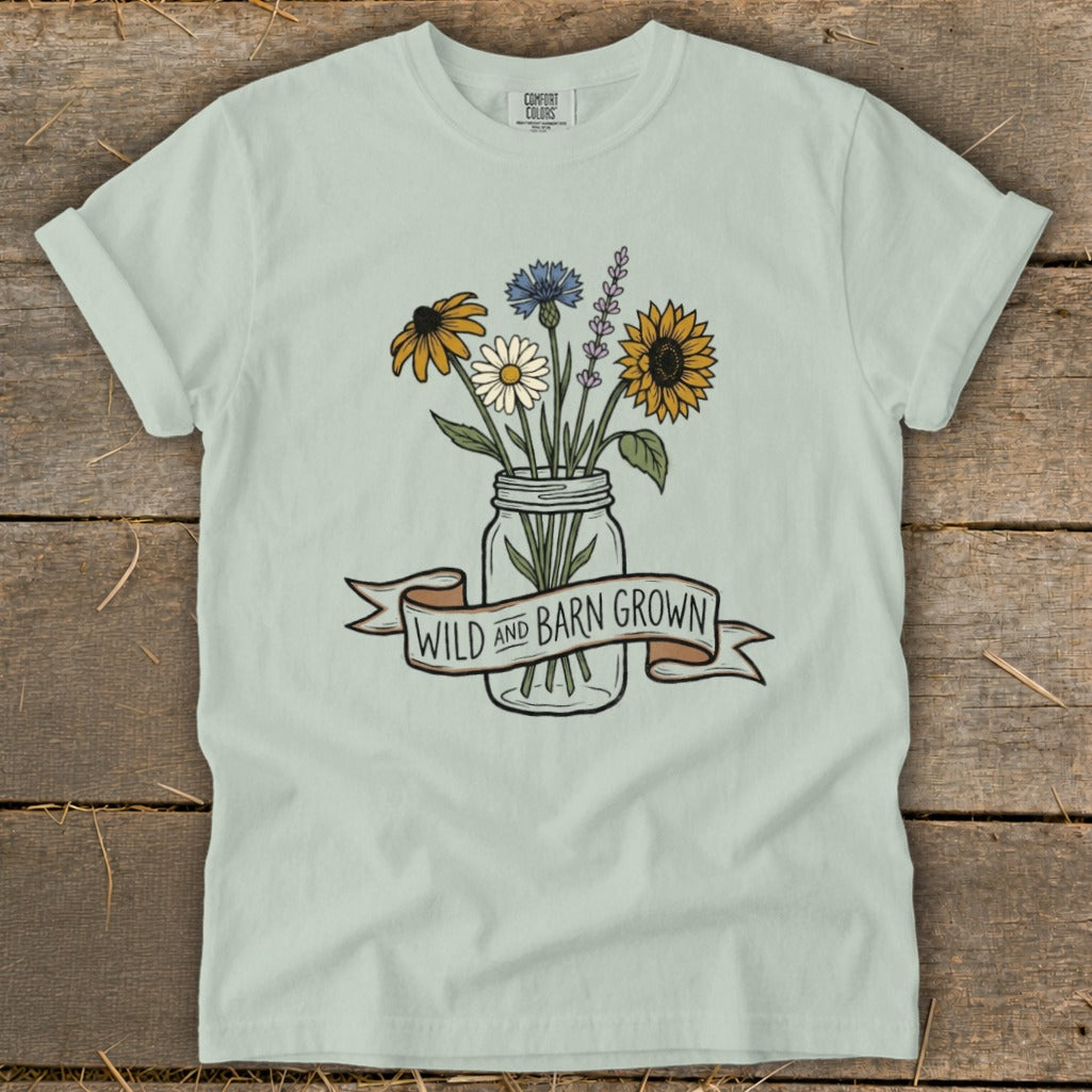 Light blue t-shirt with wildflowers in a jar and "WILD AND BARN GROWN" banner.