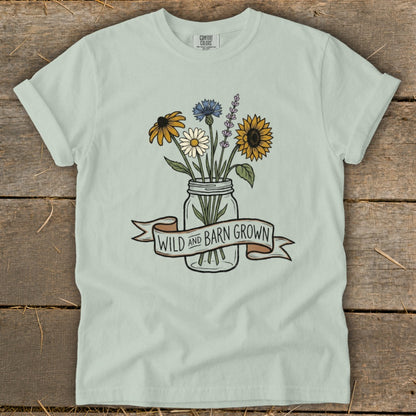 Light blue t-shirt with wildflowers in a jar and "WILD AND BARN GROWN" banner.