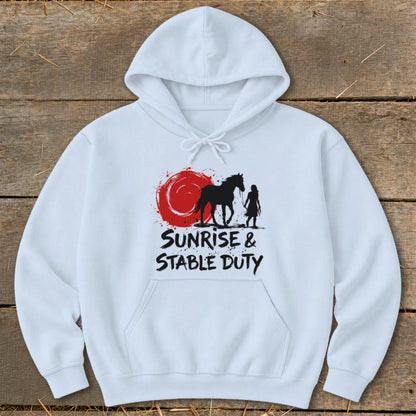 White hoodie with black graphic of horse and rider, red sun, and text "Sunrise & Stable Duty".