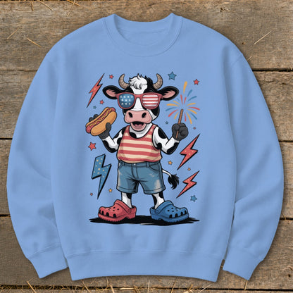 Cartoon cow with sunglasses and hot dog, celebrating Fourth of July.