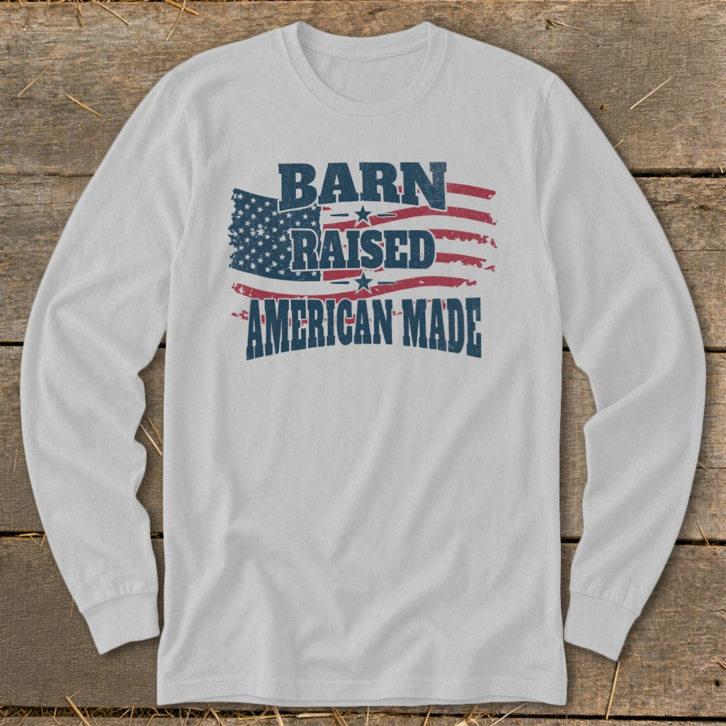 White long-sleeve shirt with distressed American flag and text: "BARN RAISED AMERICAN MADE".