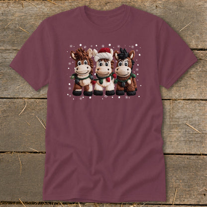 Three cartoon horses wearing holiday lights and a Santa hat on a burgundy shirt.