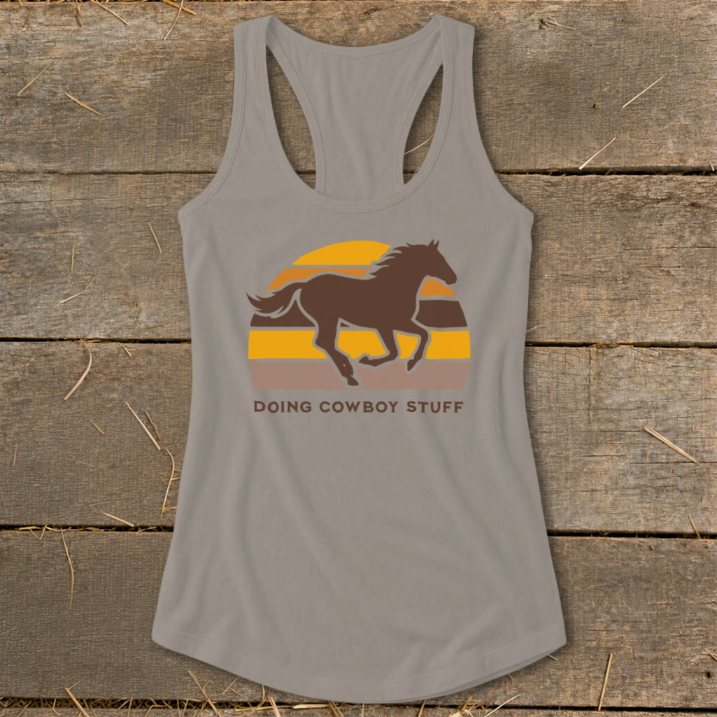 Gray tank top with a brown running horse over a striped sunset and text "DOING COWBOY STUFF".