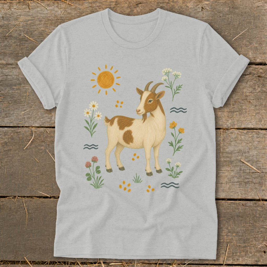 Light grey t-shirt with a cartoon brown and white goat surrounded by flowers and sun.