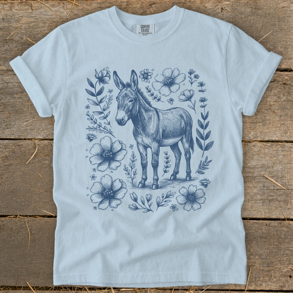 Light blue t-shirt with a navy blue donkey illustration surrounded by flowers.