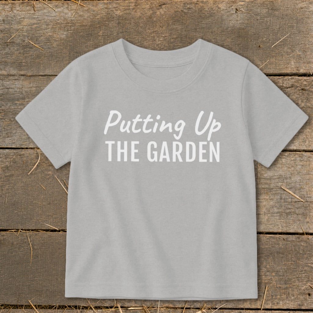 Light gray t-shirt with white text "Putting Up THE GARDEN"