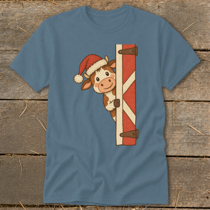 Cute cow wearing Santa hat peeking from behind a barn door.