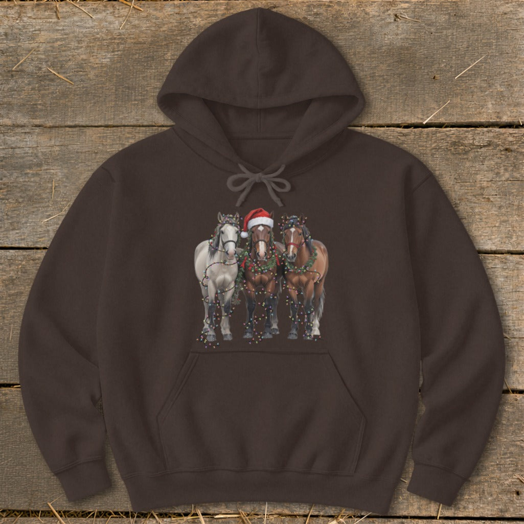 Three horses, one with a Santa hat, decorated with Christmas lights.