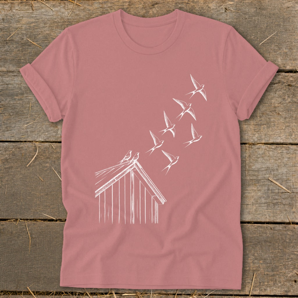 Mauve crewneck t-shirt featuring a white line drawing of birds flying from a small wooden coop.