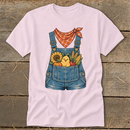 Pink t-shirt with a denim overalls graphic featuring a chick and fall harvest items.