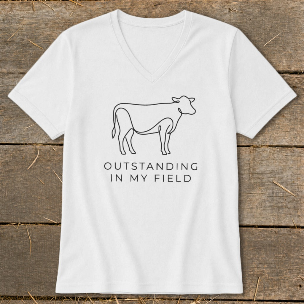 White v-neck shirt with black line drawing of a cow and text "Outstanding In My Field".