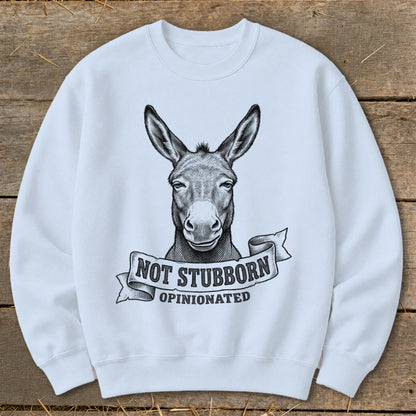 White sweatshirt with black graphic of a donkey's head on a banner reading "NOT STUBBORN OPINIONATED".