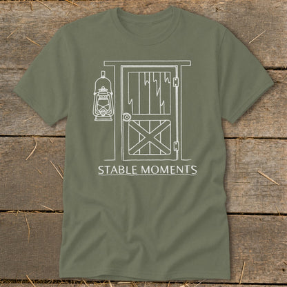 Olive t-shirt with white line art of barn door, lantern, and text "STABLE MOMENTS".