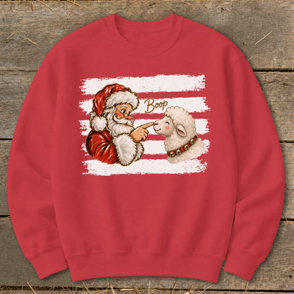 Santa boops a sheep's nose with "Boop" text on a red sweatshirt.