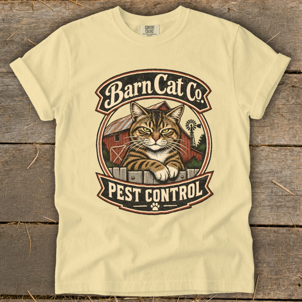 A light yellow t-shirt features a vintage circular logo with a tabby cat, a red barn, and the text "Barn Cat Co. Pest Control."