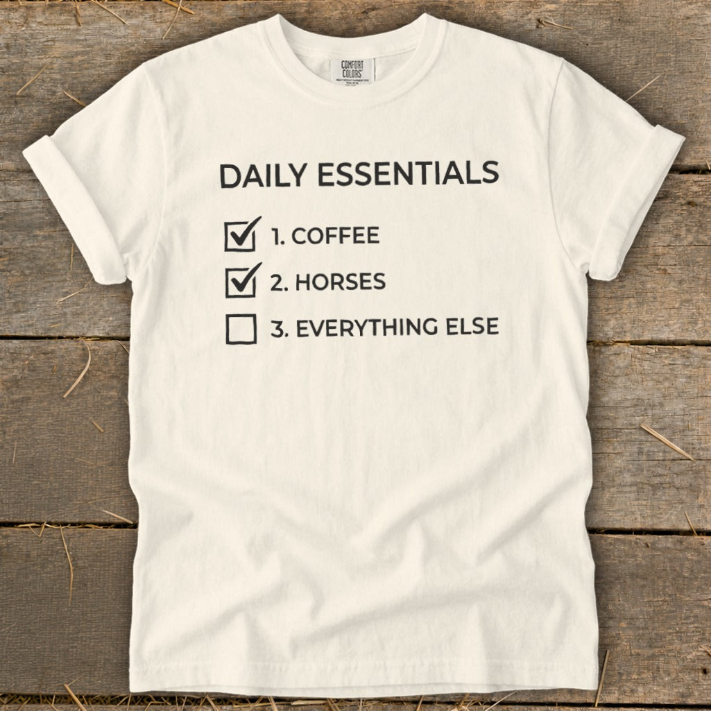 White t-shirt with "Daily Essentials" checklist: 1. Coffee, 2. Horses, 3. Everything else.