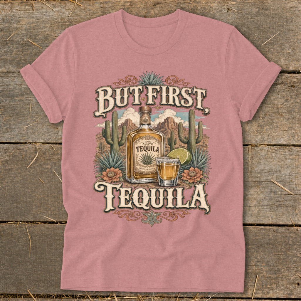 Pink t-shirt with "But First, Tequila" graphic featuring a tequila bottle, shot glass, and desert scene.