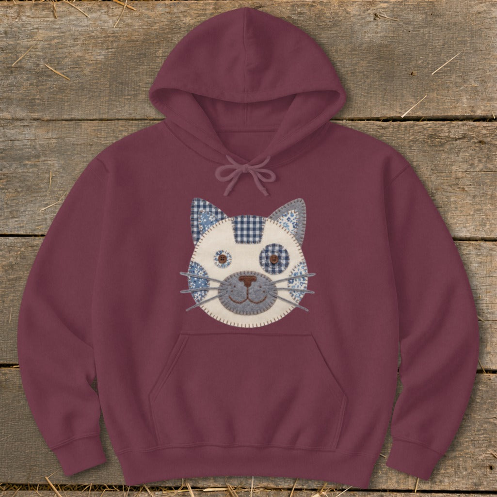 Burgundy hoodie with a patchwork cat face design on the chest.
